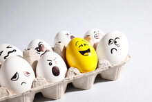 Yellow Smiley Egg Among Others With Negative Emotions In Package On Light Background