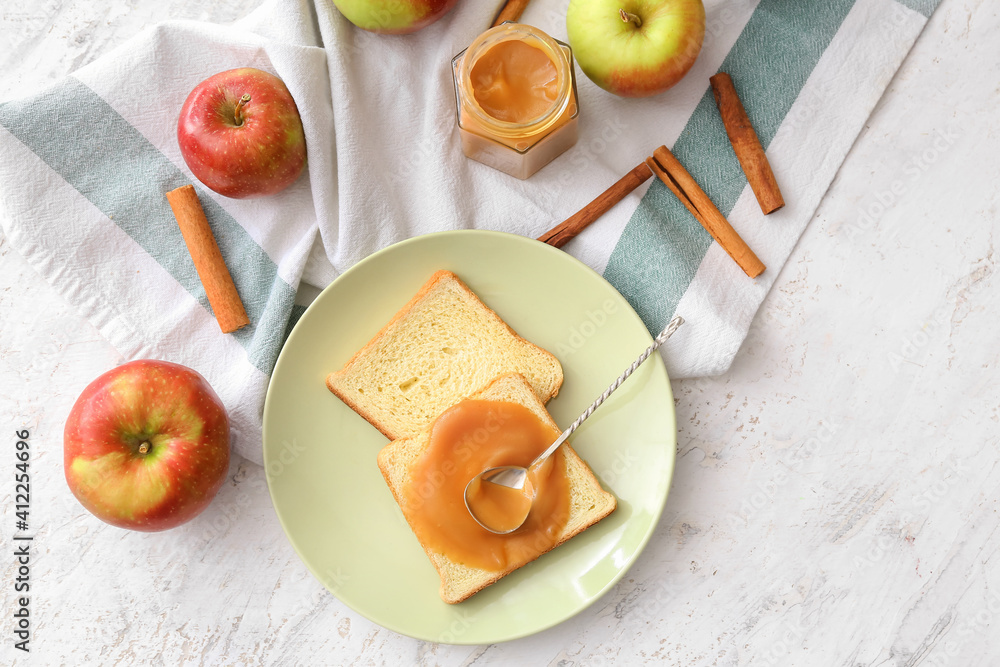 Jar and toasts with sweet apple jam on light background