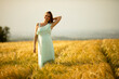 © BGStock72 - Young pregnant woman in white dress relaxing outside in nature