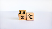 Symbol For Limiting Global Warming. Turned A Cube And Changed The Expression '2 C' To '1.5 C', Or Vice Versa. Concept. Beautiful White Table, White Background, Copy Space.