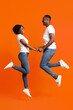© Prostock-studio - Romantic black couple in love holding hands and jumping up