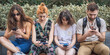 © guruXOX - Alienation addiction. Group of friends using smartphones together. Young people addiction to new technology trends. Youth, new generation internet friendship concept. Emotional isolation and depresion