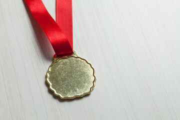 Gold medal on gray background and red bead. Olympics concept. Award concept.