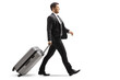 © Ljupco Smokovski - Smiling young businessman walking and pulling a suitcase