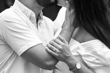 couple kissing in black and white with engagement ring