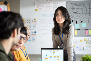 Asian female creative designers present ux ui to team.Designers team working meeting in a modern office.