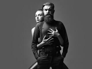 Wall Mural - Fashion couple. Pretty girl embraces handsome man hipster with beard and moustache fashion couple on grey background.