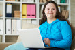 © Clique Images/Stocksy - Happy mentally challenged woman with laptop