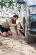 © Gillian Vann/Stocksy - man using jack on a van with flat tyre, in a rural setting