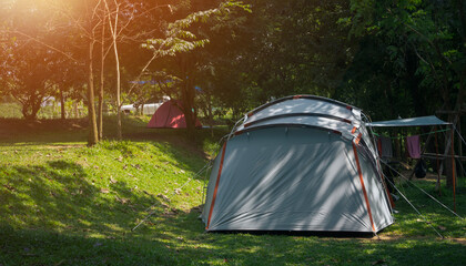 Wall Mural - sunlight and shade on surface of field tents on green lawn in camping area at natural parkland