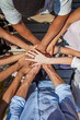 © MyMicrostock/Stocksy - Different people putting hands in stack at the office