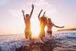 © Aila Images/Stocksy - Three Friends swimming in the sea at Sunrise