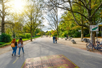 Tourists and locals enjoy an afternoon at Vondelpark, the large city park in the museum district of Amsterdam, Netherlands in early autumn.