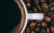 © Ilya/Stocksy - Roasted coffee beans and white coffee cup filled with fresh hot black coffee
