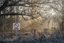Sunlight Through Mist And Military Firing Range Sign.