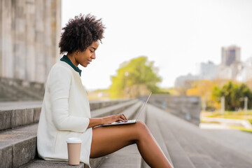 Business woman using her laptop outdoors.