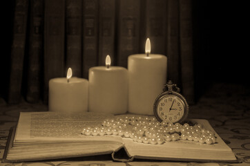 old book with candle and  old watch