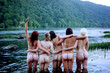 © Peyton Weikert/Stocksy - Young nude girl friends having fun and hugging outside and standing in a river