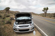 © Matthew Spaulding/Stocksy - Car broken down on side of road in desert