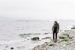 © Daniel Kim Photography/Stocksy - Female standing on cold beach