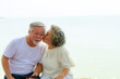 © sutthichai - Asian senior love couple travel relaxing on the beach. Retirement and recreation on summer holiday.