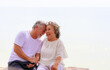 © sutthichai - Asian senior love couple travel relaxing on the beach. Retirement and recreation on summer holiday.