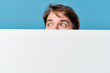 Poster - man peeking out from behind banner cropped view advertisement copy space blue background