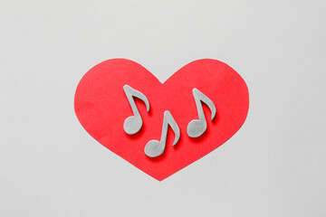 Music notes and red heart on light background