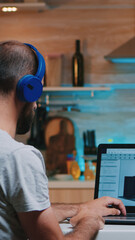 Man designer using cad software to design a 3D concept of buildings working overtime from home. Industrial male employee studying prototype idea on personal computer looking on device display