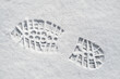 Clearly defined footprint / imprint in fresh snow of rubber lug sole with deep indentations from mountaineering boot / hiking boot in winter