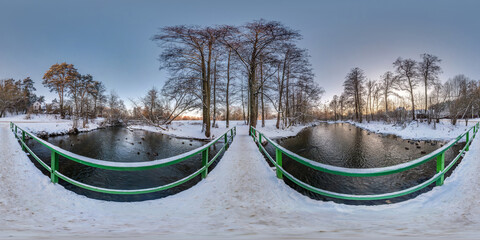 Wall Mural - full winter seamless spherical hdri panorama 360 degrees  angle view on wooden bridge over small river in snowy forest in equirectangular projection, VR AR content.
