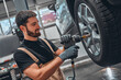 © HBS - Professional car mechanic changing car wheel at car maintenance and auto service garage.