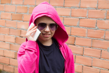 Wall Mural - young woman smiling with mobile phone and wall background