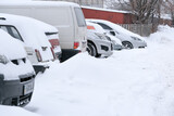 Fototapeta Uliczki - Snow covered car in an open parking
