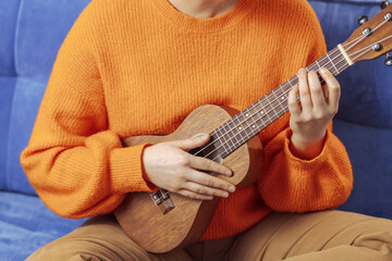 Girl playing the ukulele, close-up