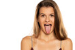 Young woman sticking het tongue out, isolated on white background.
