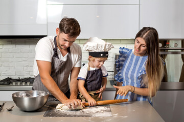 Wall Mural - Happy family in the kitchen. Make pizza dough.