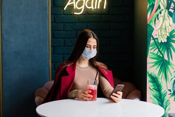 Close up portrait of a caucasian female wearing a medical mask and standing in the street and cafe