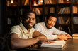 © Alexandr - two young african men are sitting at a table with books