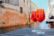 © Iryna - Two glasses of Spritz Veneziano cocktail served near the Venetian canal.  Popular italian summer aperitif drink. Place for text.