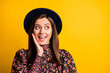 Portrait of impressed nice lady hand face look empty space wear black cap shirt isolated on vibrant yellow color background