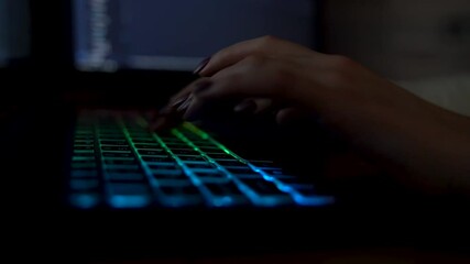 Wall Mural - closeup female hands is typing on laptop keyboard with colored backlight. software developer freelan