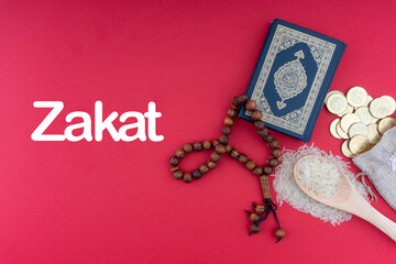 Sticker - ZAKAT words with Holy Quran, Coins, Rosary and Rice. Zakat concept. Zakat is a form of alm-giving as a religious obligation