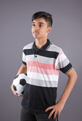 Wall Mural - Smiling Indian teen boy holding soccer ball or football	

