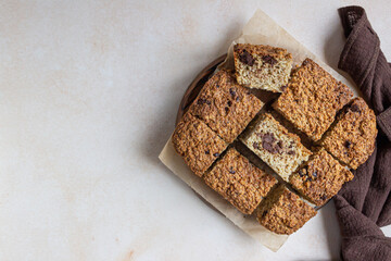 Wall Mural - Oatmeal squares with chocolate decorated, light concrete background. Diet bars. Healthy bakery for breakfast or dessert.