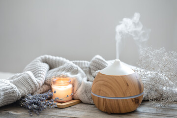 cozy home composition with air humidifier, knitted element, lavender and candle copy space.