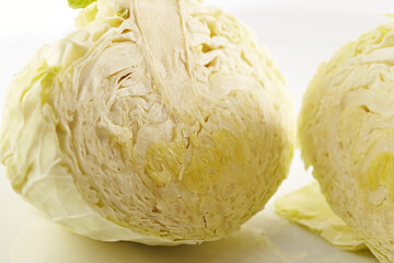 Closeup of fresh cabbage split into two parts on white background