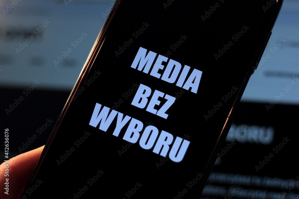 Media blackout protest in Poland. A person is holding a smartphone with the sign “Media bez wyboru” (Eng. Media without a choice) in front of a black TV screen. - obrazy, fototapety, plakaty 