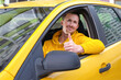 © Elena - Young happy male taxi driver sits behind the wheel of a taxi