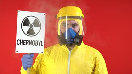 Wall Mural - Man in Protective Chemical Suit, Mask and Banner in Hands. Chernobyl. Smoke Around Man. Isolate, Studio. Protection concept, radioactive hazard concept.